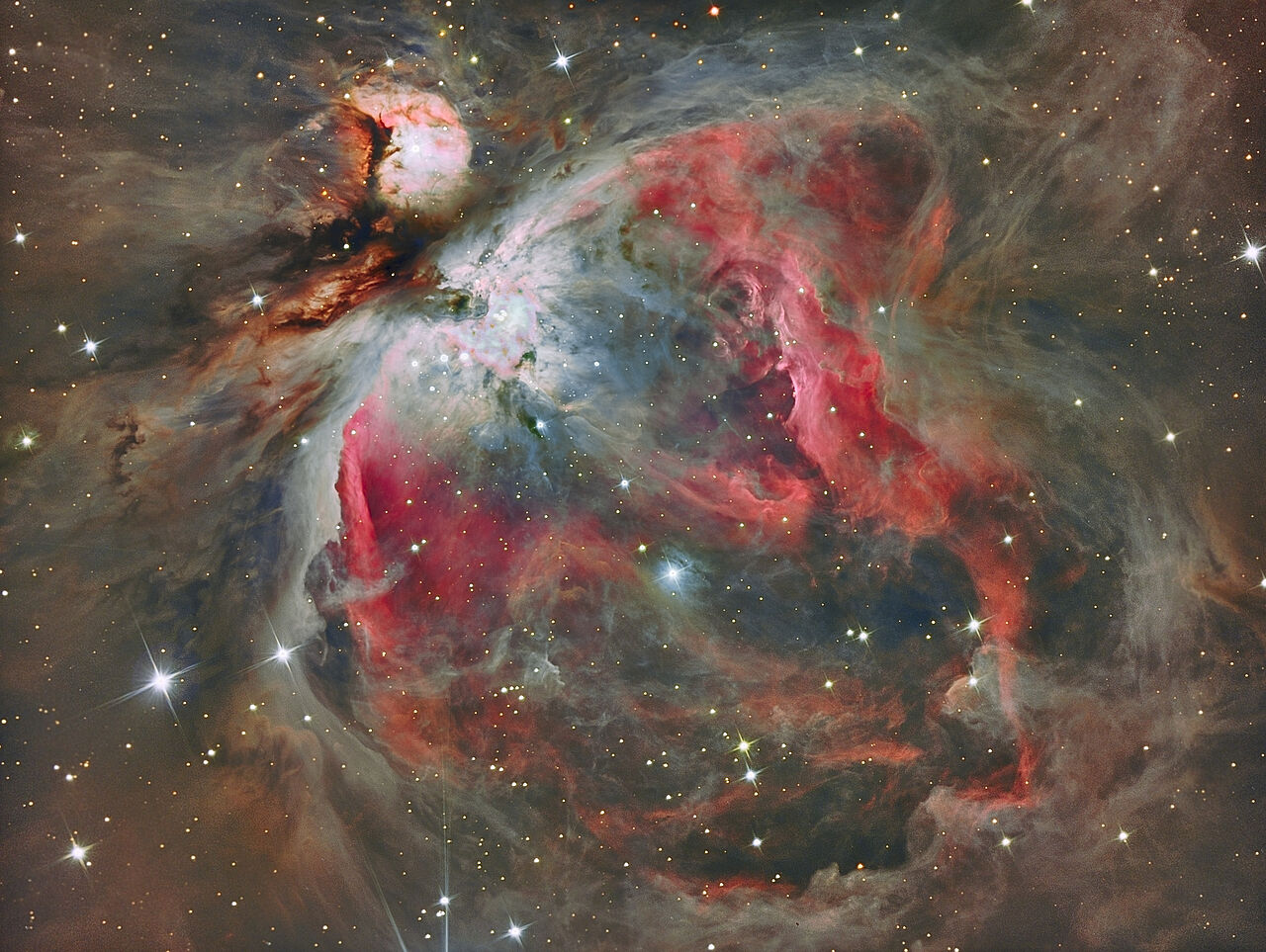 Zu sehen ist der Orion-Nebel in bunten Farbtönen und umgeben von Sternen.
